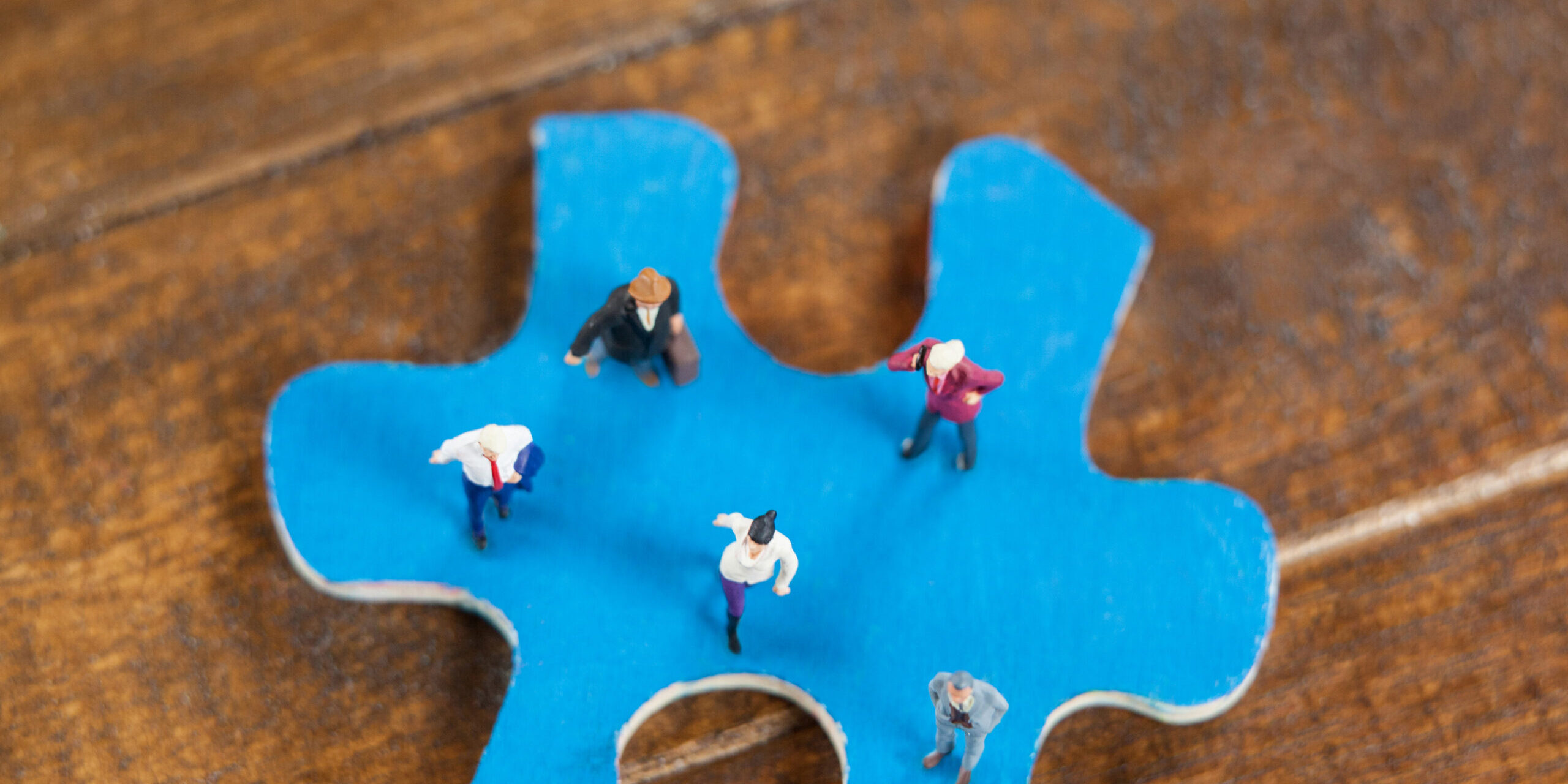 Miniature people on a jigsaw puzzle